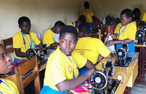 Rwandan children learning how to use sewing machines
