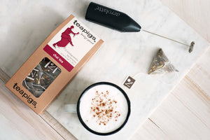 chai latte pictured next to a temple, electric whisk and mug