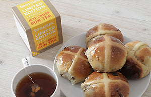 5 tasty hot cross buns next to a mug of teapigs tea