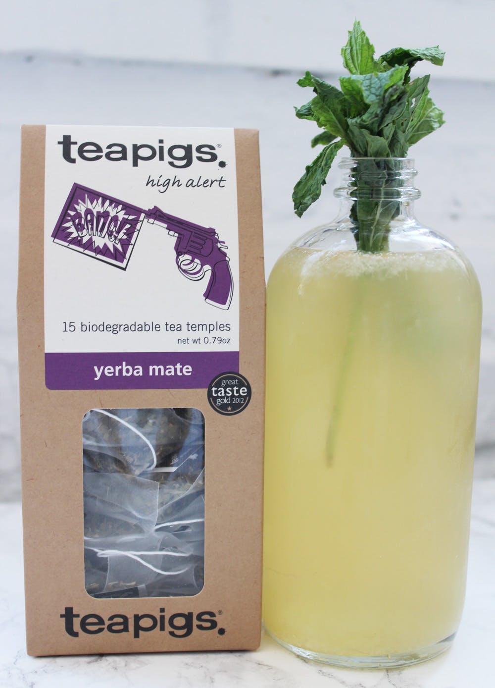 teapigs yerba mate tea in a box next to a bottle of tea being brewed
